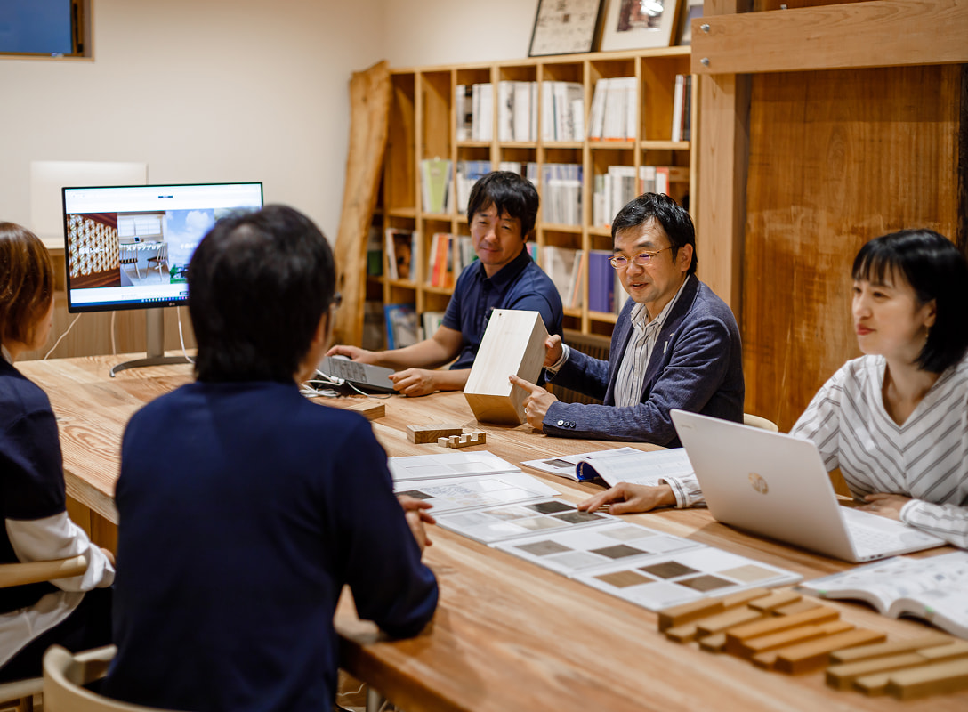 木材サンプルを使って打ち合わせする設計チーム