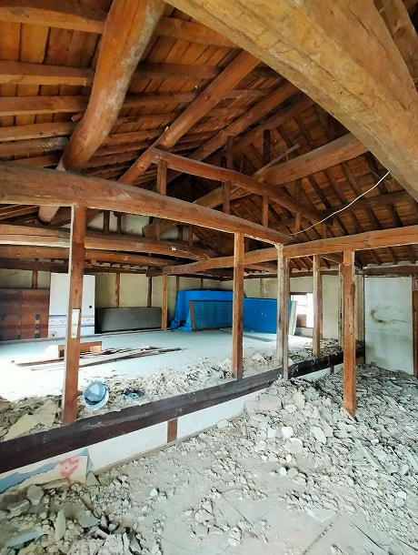 古民家の太い梁と屋根裏構造が見える内部の様子