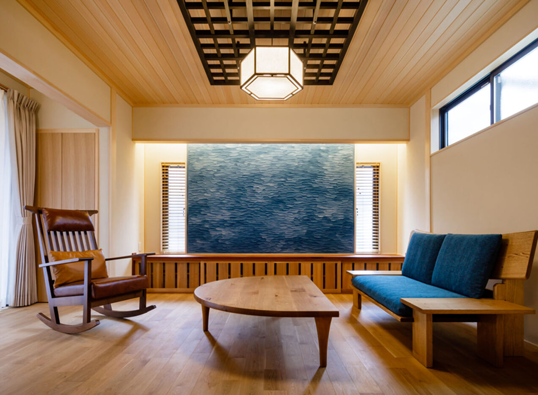 木製家具と青いソファが調和する和モダンなリビング空間